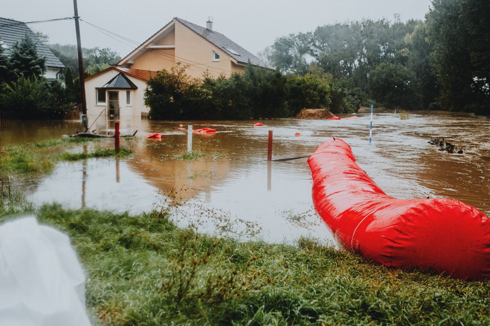 Red flood barriers deployed in a flooded residential area