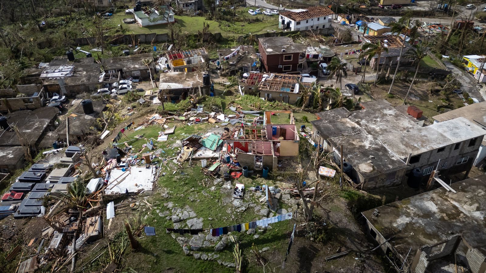 Aerial view of a residential area with extensive hurricane damage to roofs and homes