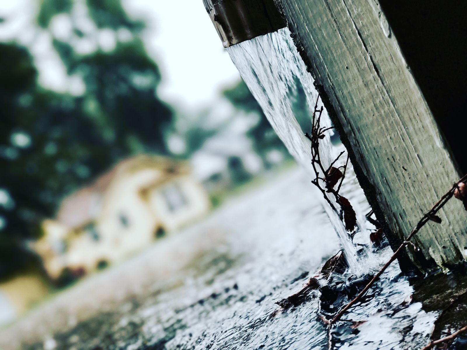 Rainwater pouring from a downspout during a storm