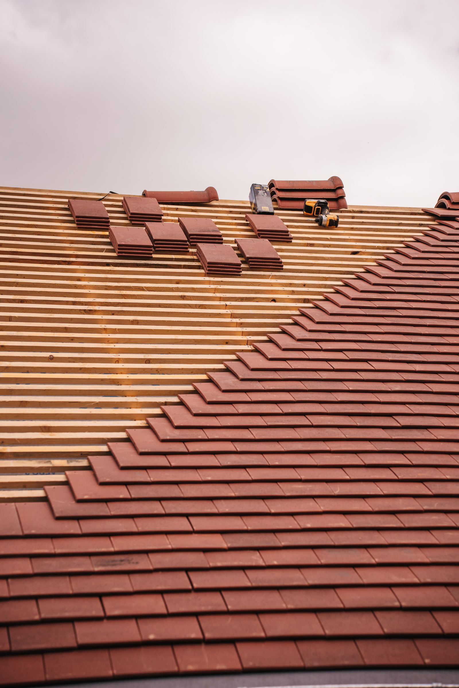 Roof tiles being installed over wooden battens during a re-roof