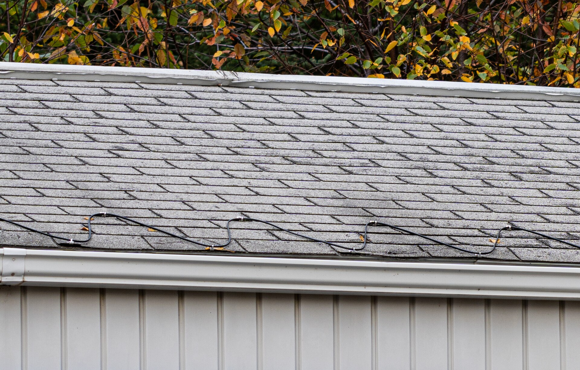 De-icing heat cable installed in a zigzag along a shingled roof edge above a gutter