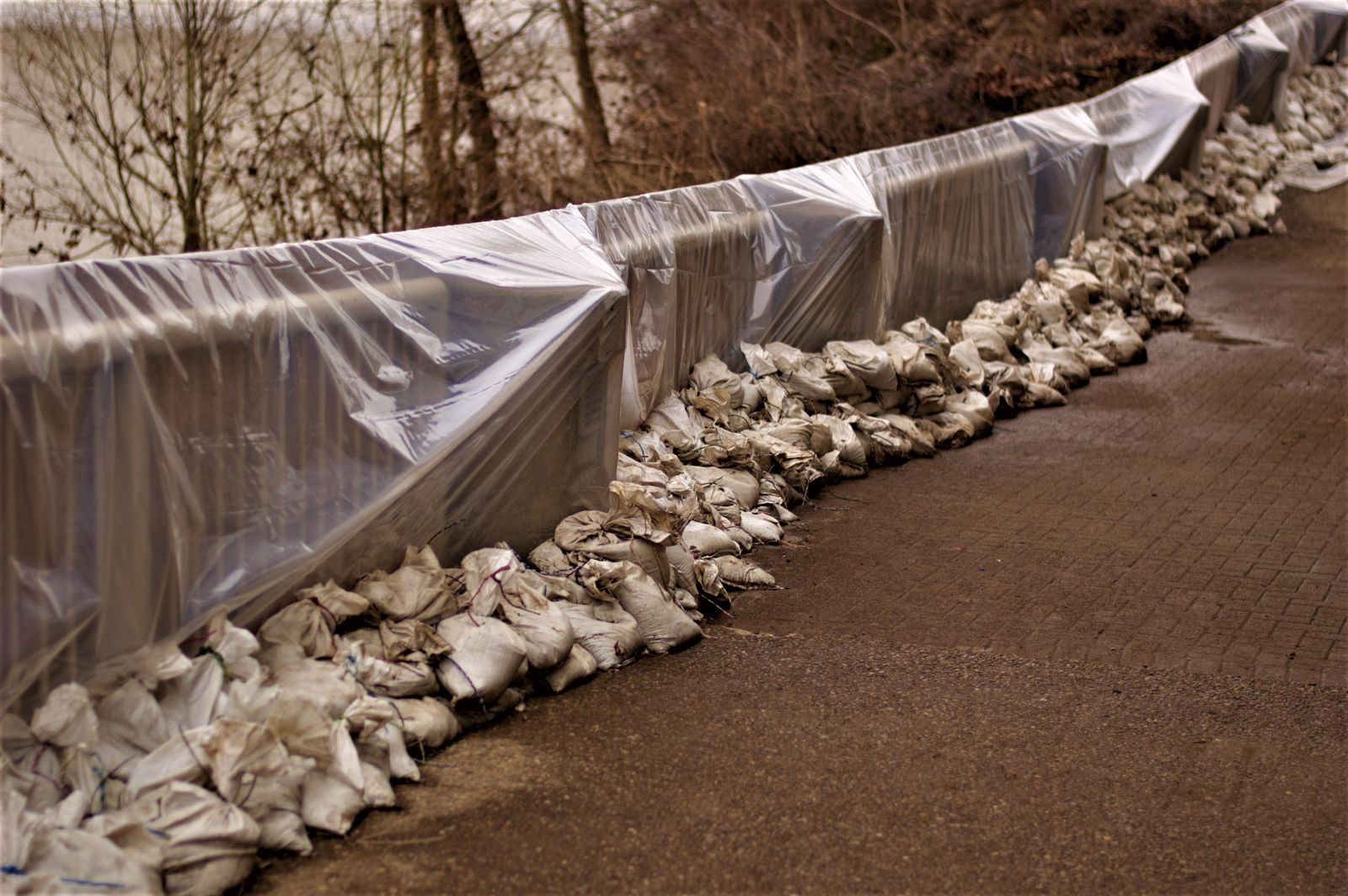 Sandbags and waterproof sheeting lined up to protect a home from floodwater